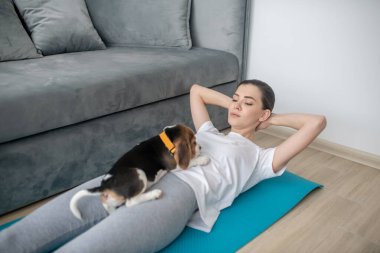 Yavru köpeğiyle antrenman yapan genç bir kadın.