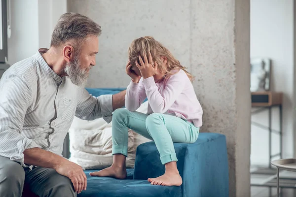 Ein Mann im Gespräch mit seiner aufgebrachten kleinen Tochter — Stockfoto