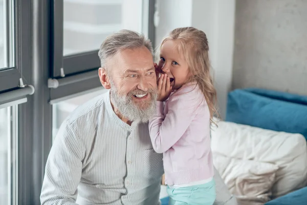 Een schattig blond meisje delen geheimen met haar vader — Stockfoto