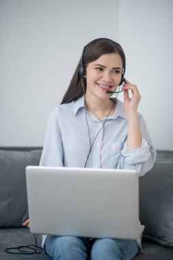Koyu renk saçlı, evden çalışan bir çağrı operatörü.