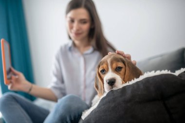Yavru köpeğiyle selfie çeken ve mutlu görünen genç bir kadın.