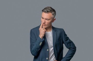 Gri arka planda ciddi düşünceli adam