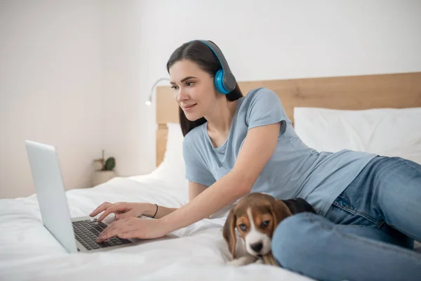 Jovem de cabelos escuros ouvindo música e passando tempo online — Fotografia de Stock