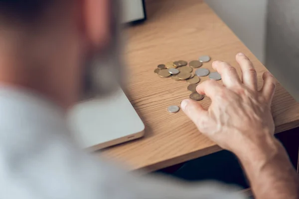 Close-up afbeelding van een man die munten berekent op de tafel — Stockfoto