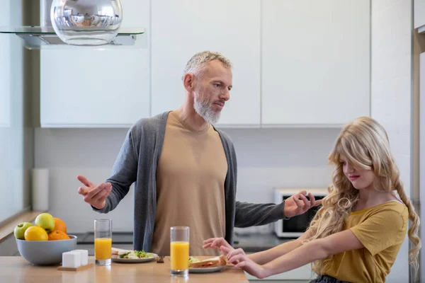 Dad trying to make his daughter eat breakfast — Stock Photo, Image