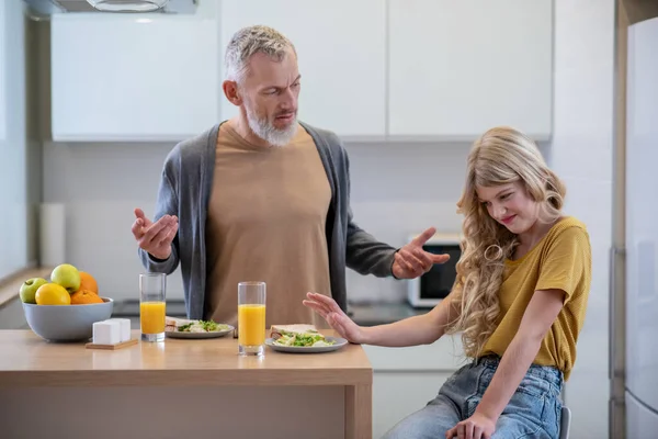 Dad trying to make his daughter eat breakfast — Stock Photo, Image