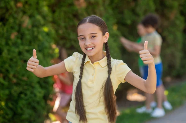 Mädchen mit Zöpfen zeigt Ok-Zeichen mit Finger — Stockfoto