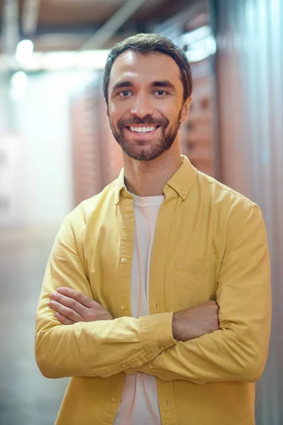 Usmívající se muž stojí v osvětlené místnosti — Stock fotografie