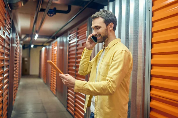 Muž s tabletem mluví na smartphonu — Stock fotografie