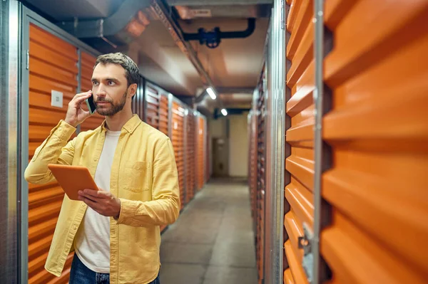 Homme avec tablette et smartphone inspectant l'entrepôt — Photo