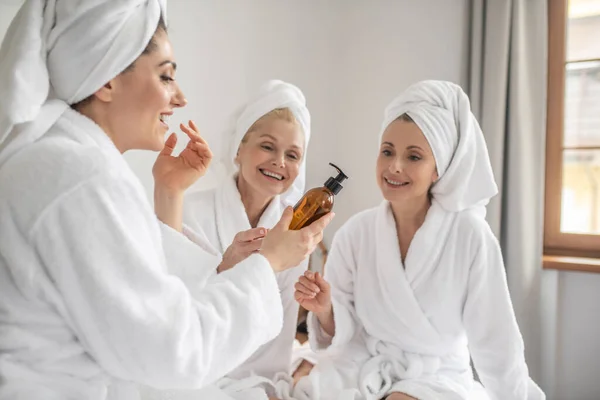 Kobiety w szlafrokach próbują nowego kosmetyku — Zdjęcie stockowe