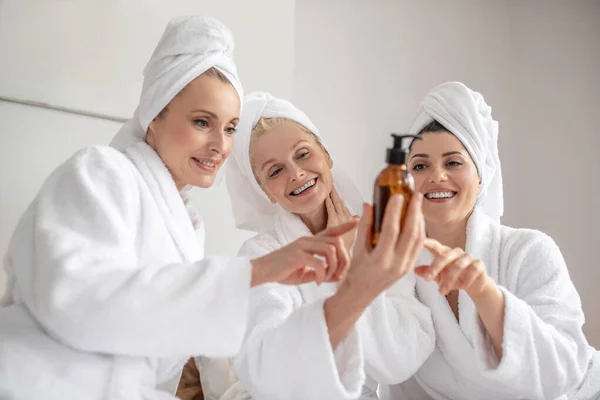 Kobiety z entuzjazmem rozważają produkt kosmetyczny — Zdjęcie stockowe