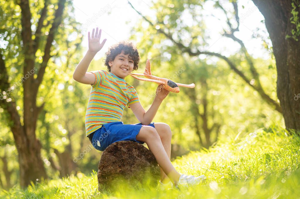 Smiling boy with toy airplane in park