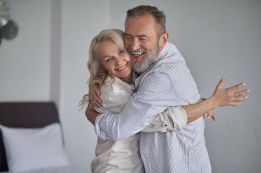 Mutlu, olgun, birbirini kucaklayan bir çift.