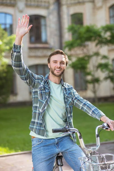 Uma foto de um jovem de camisa xadrez em uma bicicleta — Fotografia de Stock