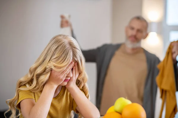 A blonde cute girl feeling frustrated while her father shouting at her — ストック写真