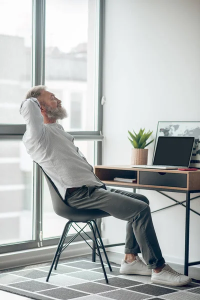 A mature self-employed man working at home and looking tired — Stock Photo, Image