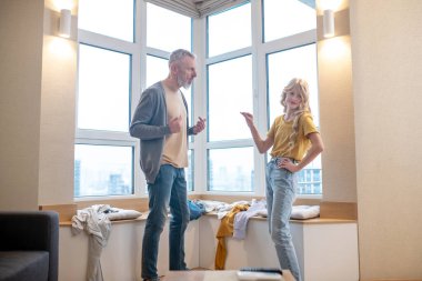 Gri saçlı bir adam ergen kızıyla tartışıyor.