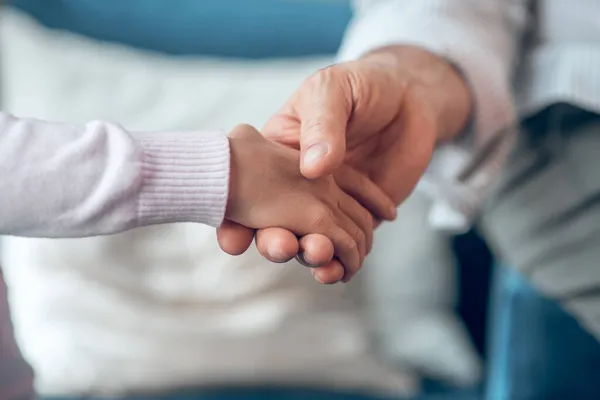 Close up picture of a mans hand holding kids hand — Stock Photo, Image