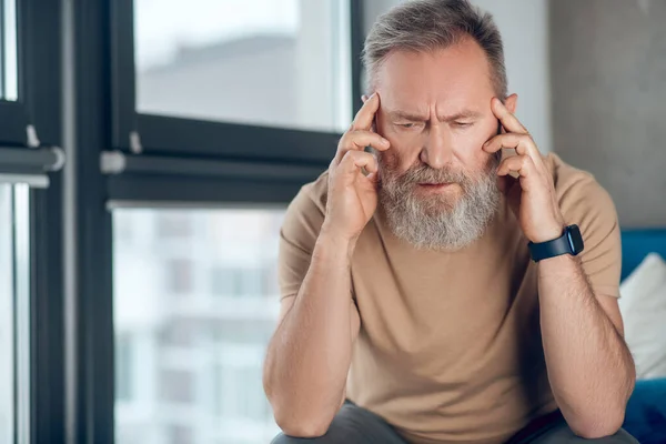 Olgun sakallı bir adam baş ağrısı çekiyor. — Stok fotoğraf