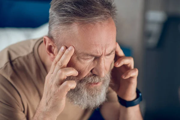 Зрілий бородатий чоловік страждає від головного болю — стокове фото