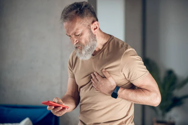 Un hombre barbudo de mediana edad que tiene un ataque al corazón —  Fotos de Stock