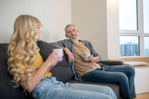 Padre e hija sentados en el sofá en casa — Foto de Stock