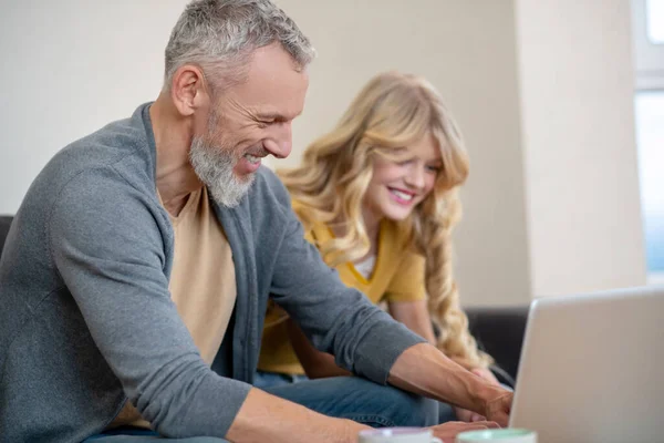 Far och dotter tittar på något på en bärbar dator — Stockfoto