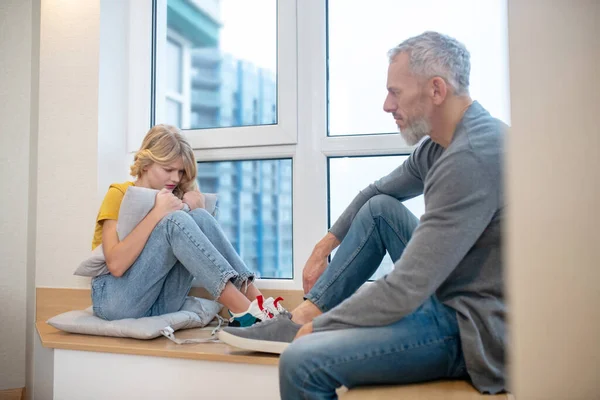 Een blond meisje delen van haar slechte humeur met haar vader — Stockfoto