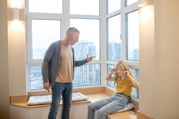 Un hombre de pelo gris teniendo una dura charla con su hija adolescente — Foto de Stock