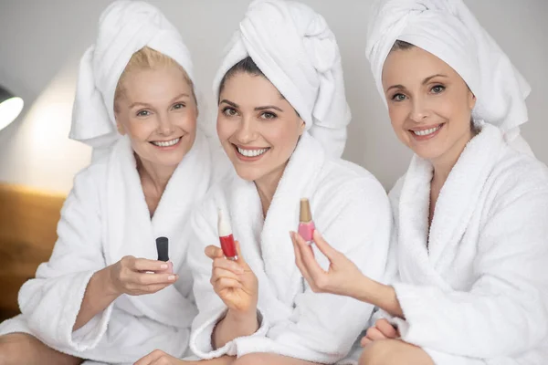 Mujeres sonrientes con esmalte de uñas en las manos — Foto de Stock