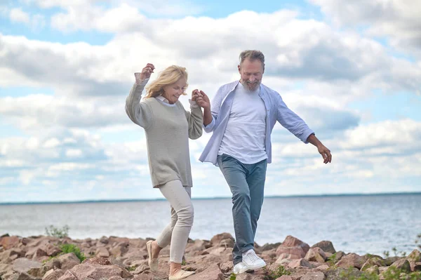 Hombre y mujer adultos caminando en la orilla del mar —  Fotos de Stock