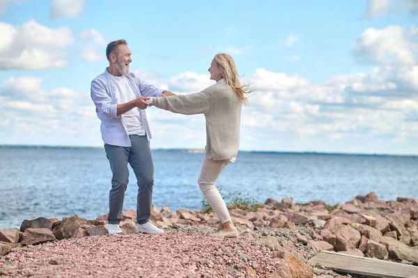 Energetischer und glücklicher Mann und Frau in der Nähe des Meeres — Stockfoto