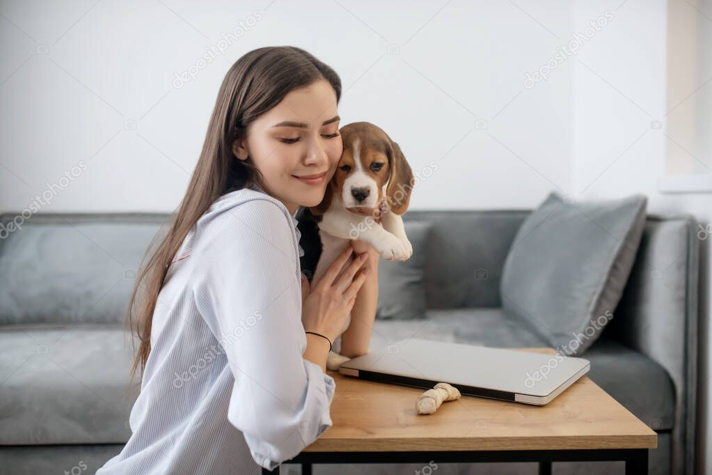 A picture of a young woman with a cute little beagle