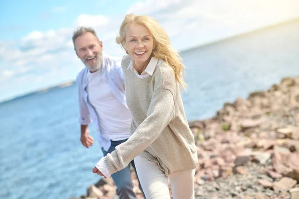 Energetikus csinos nő és férfi fut közel a tengerhez — Stock Fotó
