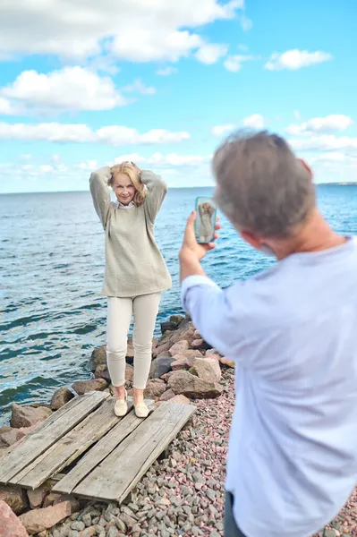 Hombre con smartphone fotografiando posando mujer — Foto de Stock