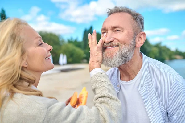 Любимая женщина с солнцезащитным кремом и счастливый мужчина — стоковое фото