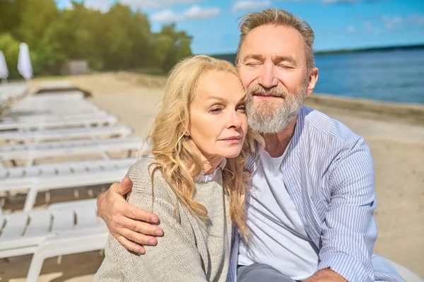 Hombre con los ojos cerrados abrazando mujer sonriente — Foto de Stock