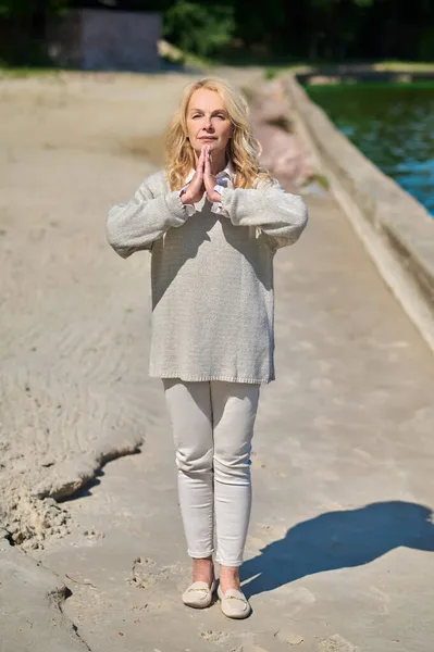 Vrouw staande in yoga poseren door zee — Stockfoto