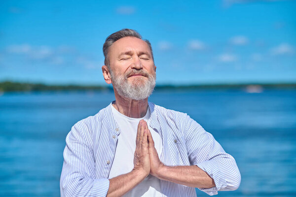 Man with closed eyes meditating in nature