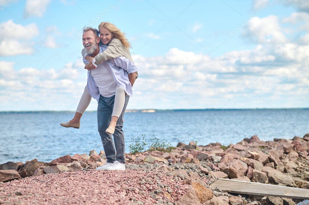 Man holding smiling woman on his back