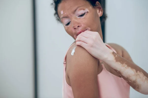 A cute woman applying cream on her body — Stock Photo, Image