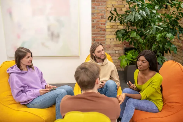 Un gruppo di giovani seduti insieme a discutere di qualcosa — Foto Stock