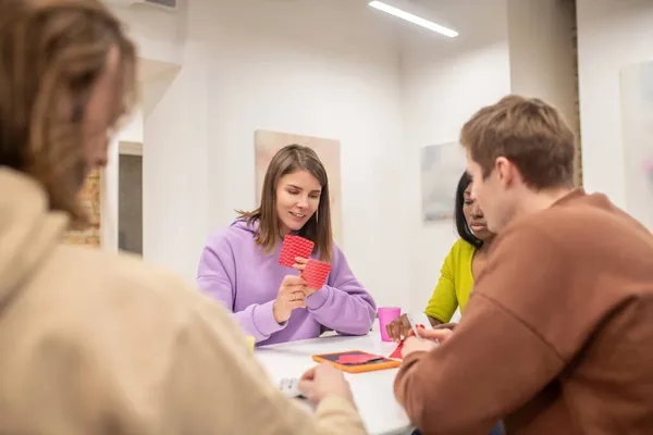 Amigos sentados a la mesa y jugando a las cartas — Foto de Stock