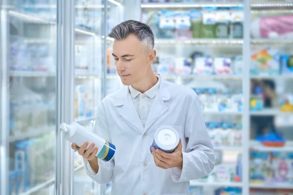 Zufriedener Mann im weißen Kittel mit Medizinprodukten — Stockfoto