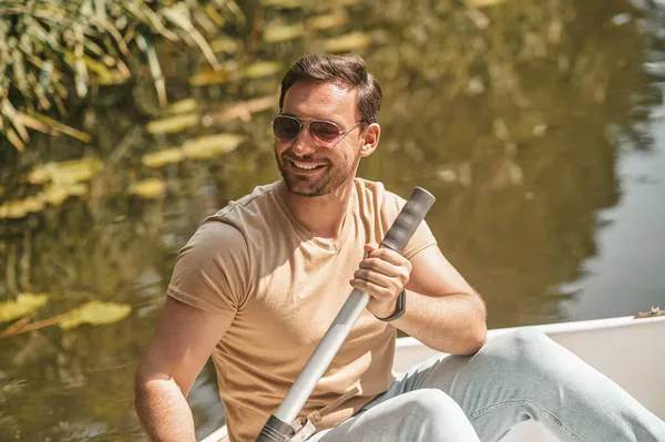 Szczęśliwy człowiek z wiosłem w łodzi — Zdjęcie stockowe