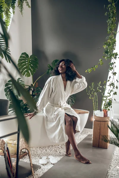 Leuke jonge vrouw in een witte badjas ontspannen — Stockfoto