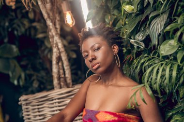 Ciddi genç bayan kameraya dikkatle bakıyor.