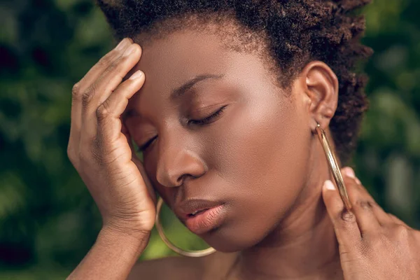 Uma mulher de pele escura que sofre forma uma dor de cabeça — Fotografia de Stock
