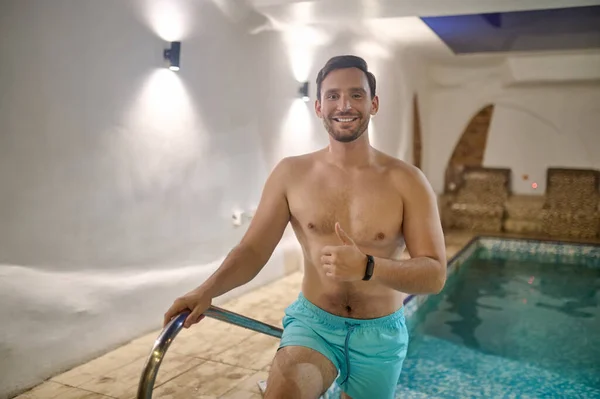 Ein Mann in blauer Hose in einem Schwimmbad — Stockfoto